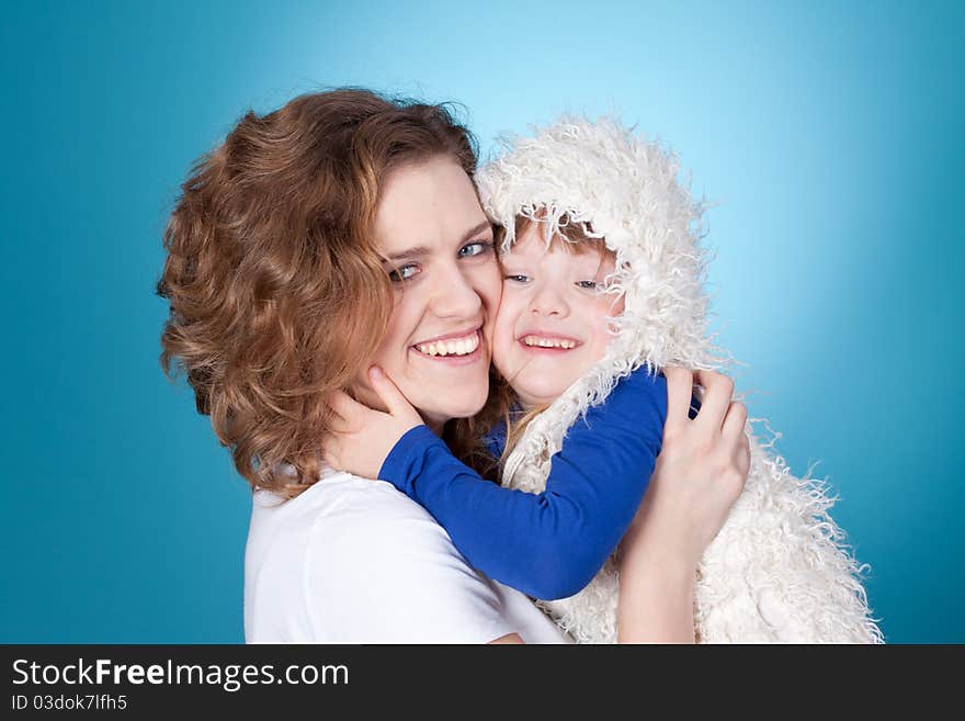 Smiling child and mom embracing, closeup portrait