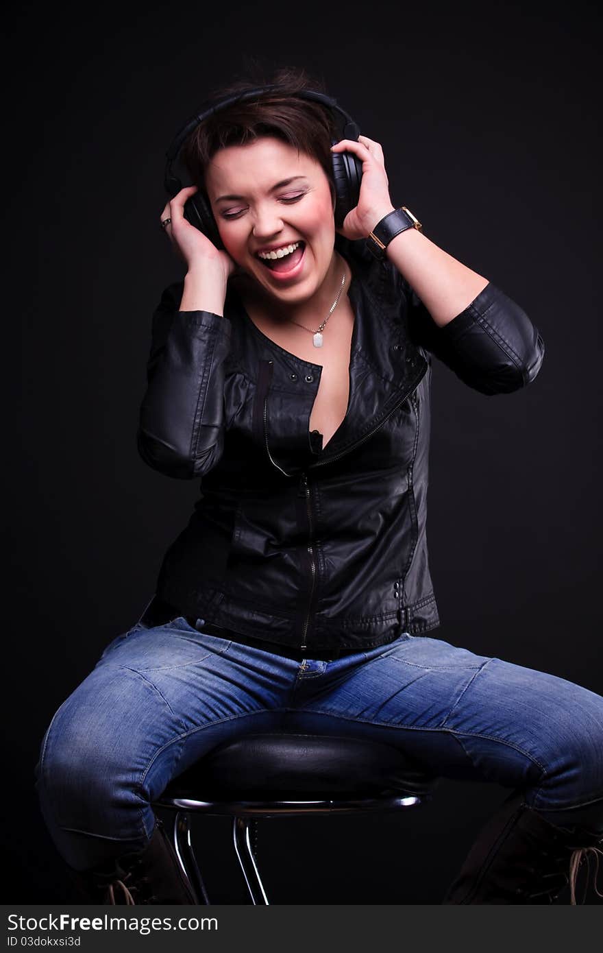 The beautiful girl in headphones sitting on the bar stool. The beautiful girl in headphones sitting on the bar stool