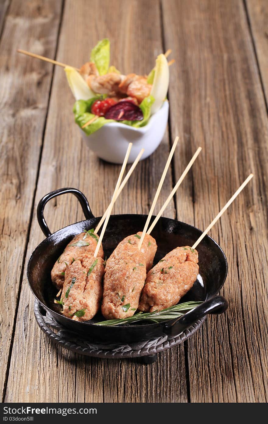 Raw minced meat kebabs on wooden skewers