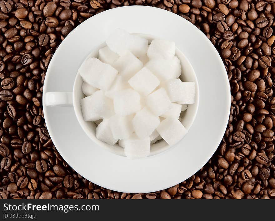 Coffee cup with beans and lump sugar