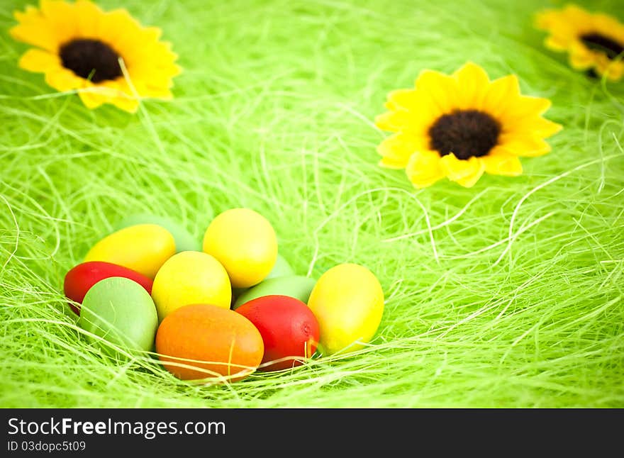 Easter composition, wood colored eggs, sunflower, green background. Easter composition, wood colored eggs, sunflower, green background.