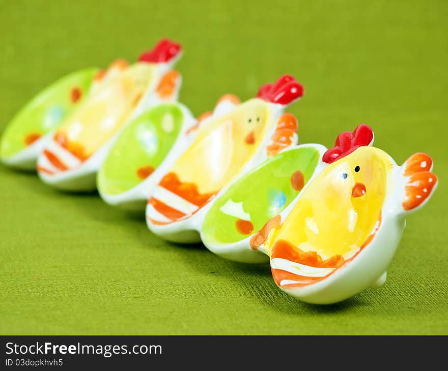 Colorful Easter eggs holder on a green flax background