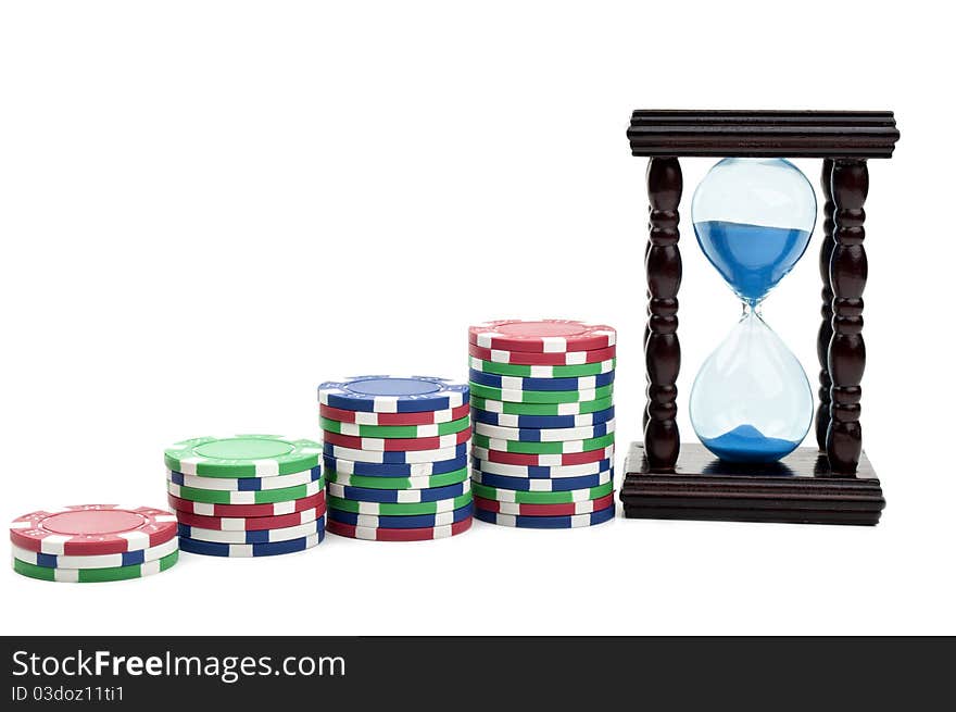 Hourglass and poker chips isolated on a white background