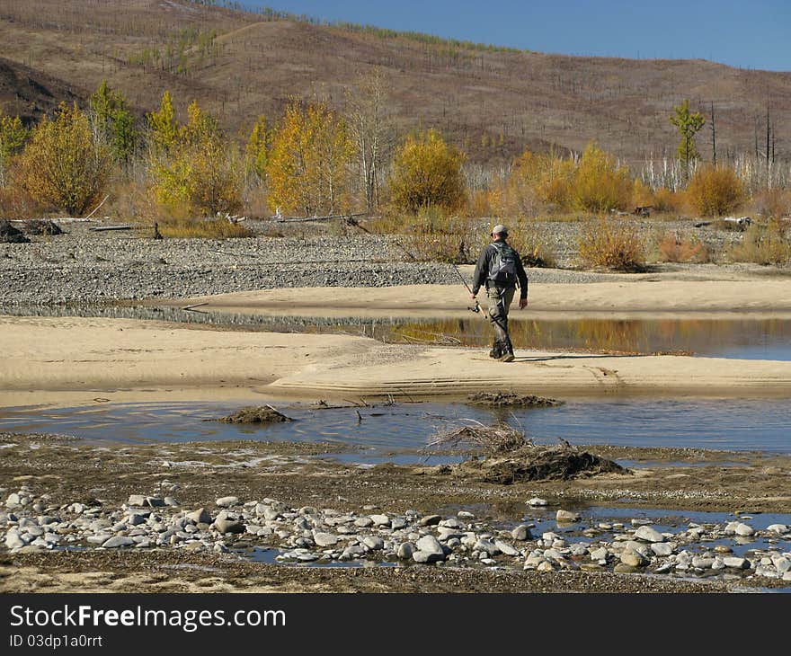 Fishing - fisherman walking to river