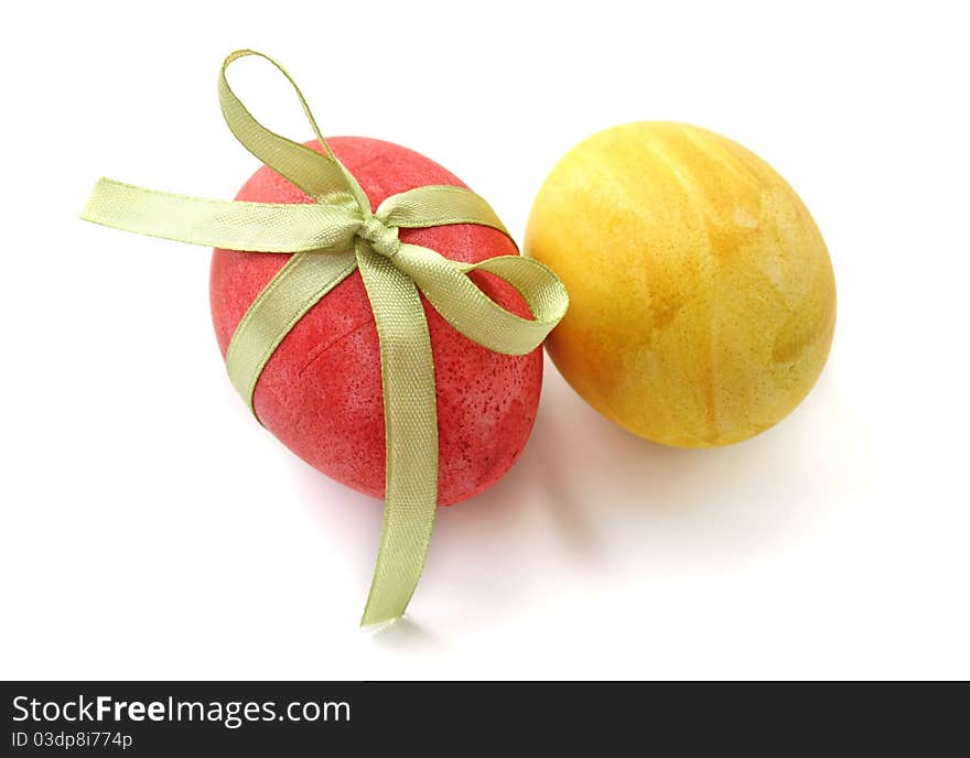 Red and yellow eggs with a bow on a white background. Red and yellow eggs with a bow on a white background