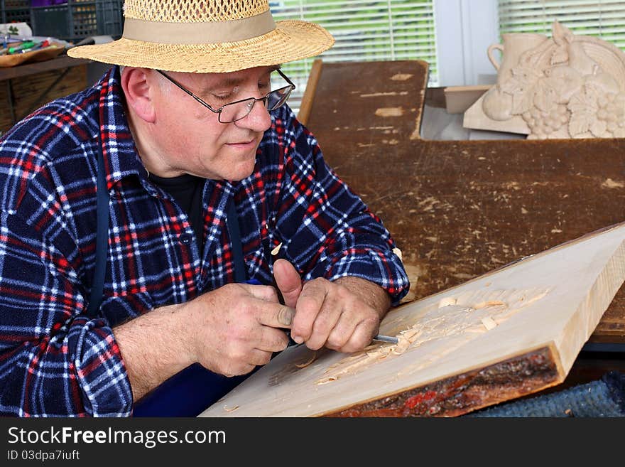 Woodcarver work in his workshop. Shallow depth of field.