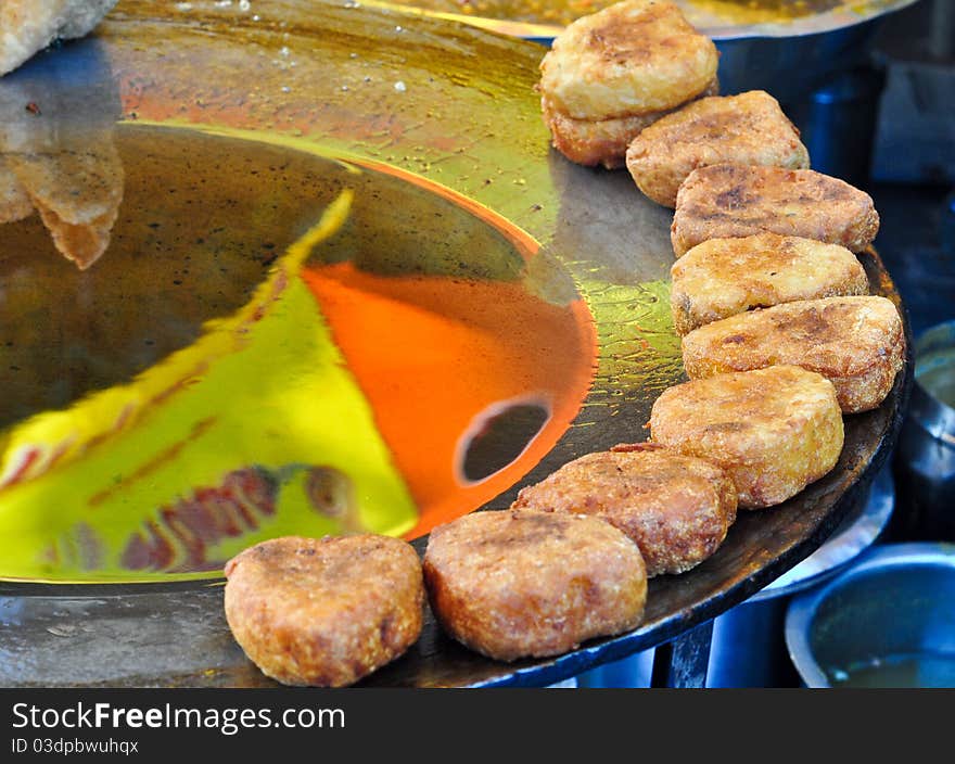 Aloo Tikki Chaat, spicy snack prepared from fried potatoes and garnished with sweet/sour sauce and Onions. A common street snack in Northern India. Aloo Tikki Chaat, spicy snack prepared from fried potatoes and garnished with sweet/sour sauce and Onions. A common street snack in Northern India