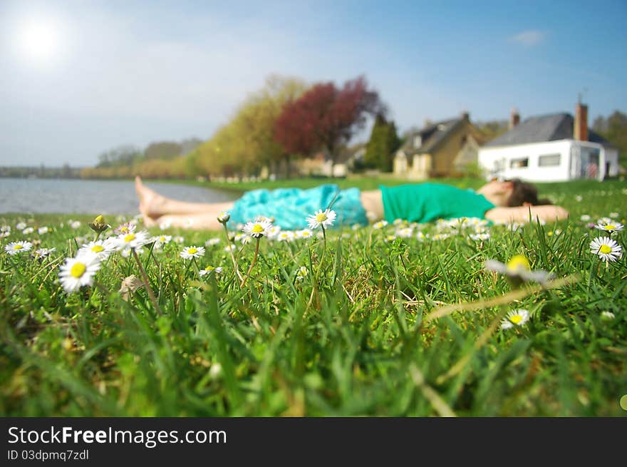 Young girl sleeping on grass near lake and caravan. Young girl sleeping on grass near lake and caravan