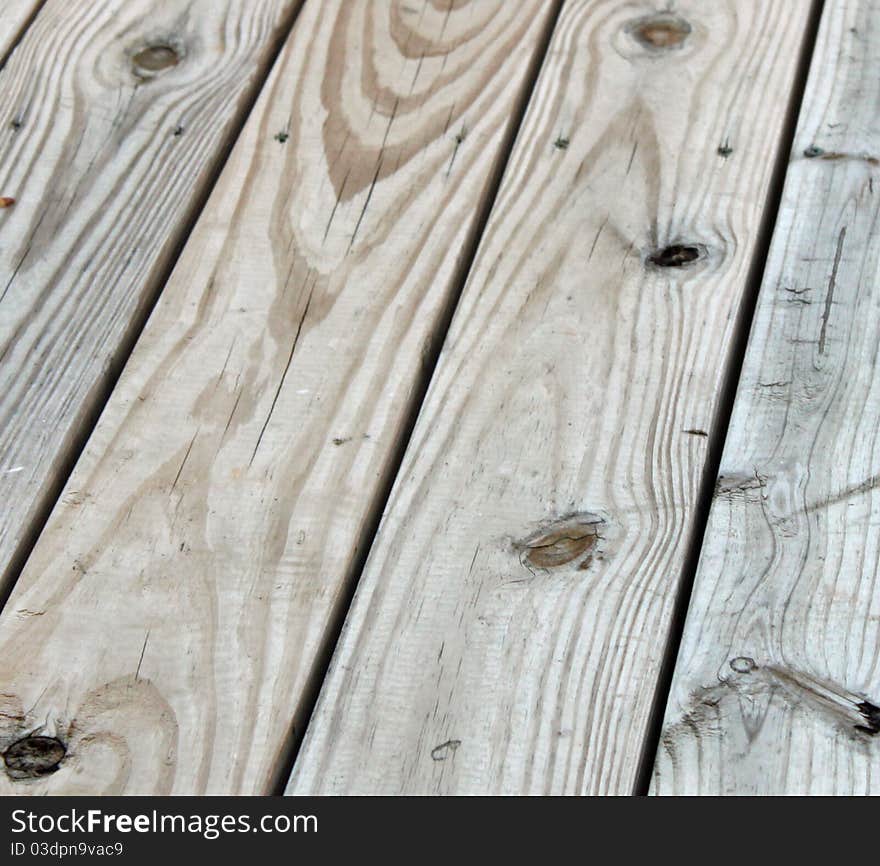 Weathered wooden planks with knot holes and tool marks visible. Weathered wooden planks with knot holes and tool marks visible