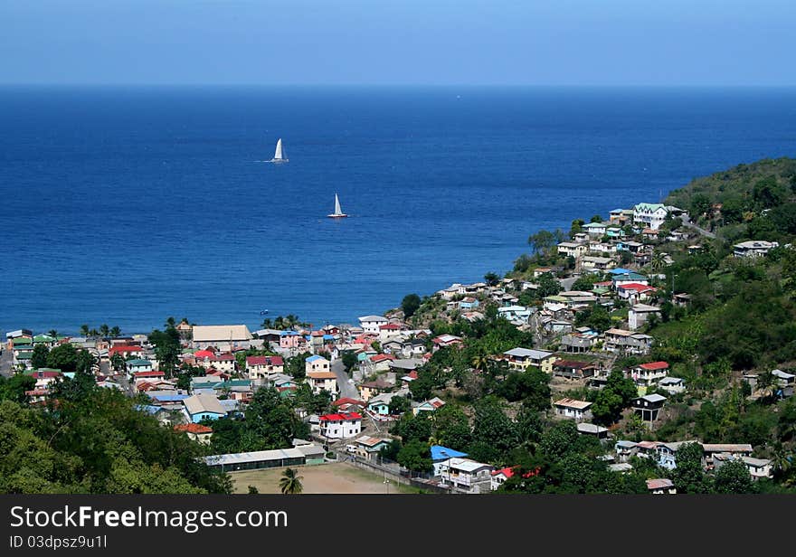 Sailboats ply the waters off the coast of a Caribbean island. Sailboats ply the waters off the coast of a Caribbean island.