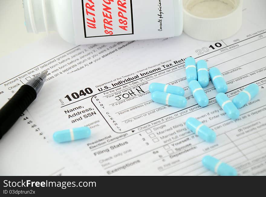 Stock photo of IRS 1040 form with aspirin and a pen with John written in so far. Stock photo of IRS 1040 form with aspirin and a pen with John written in so far.