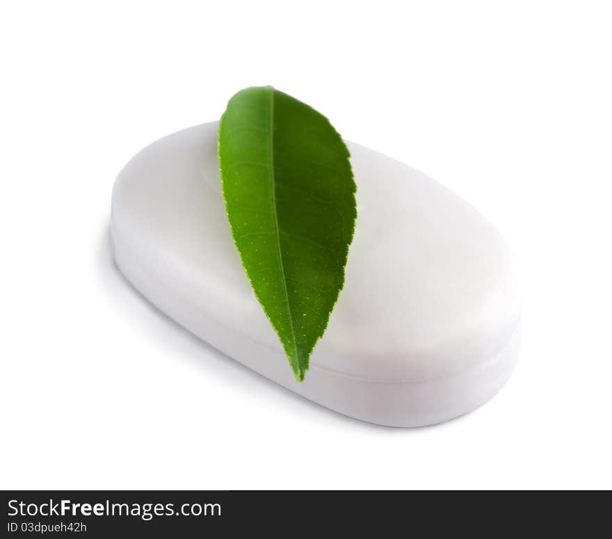 White soap bar with green leaf isolated on white background.