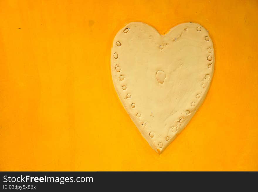 ฺBig Heart Stucco on Plain Yellow Wall. ฺBig Heart Stucco on Plain Yellow Wall