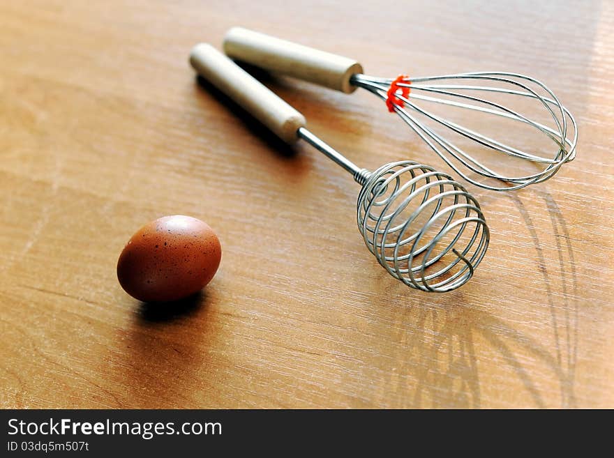 An image of an egg and whisks on the table