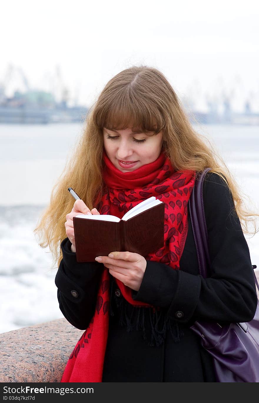 Beautiful Girl In The Red Scarf Writing In Notepad