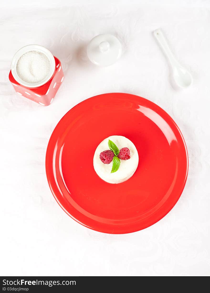 Decorated ricotta dessert over red plate. Decorated ricotta dessert over red plate