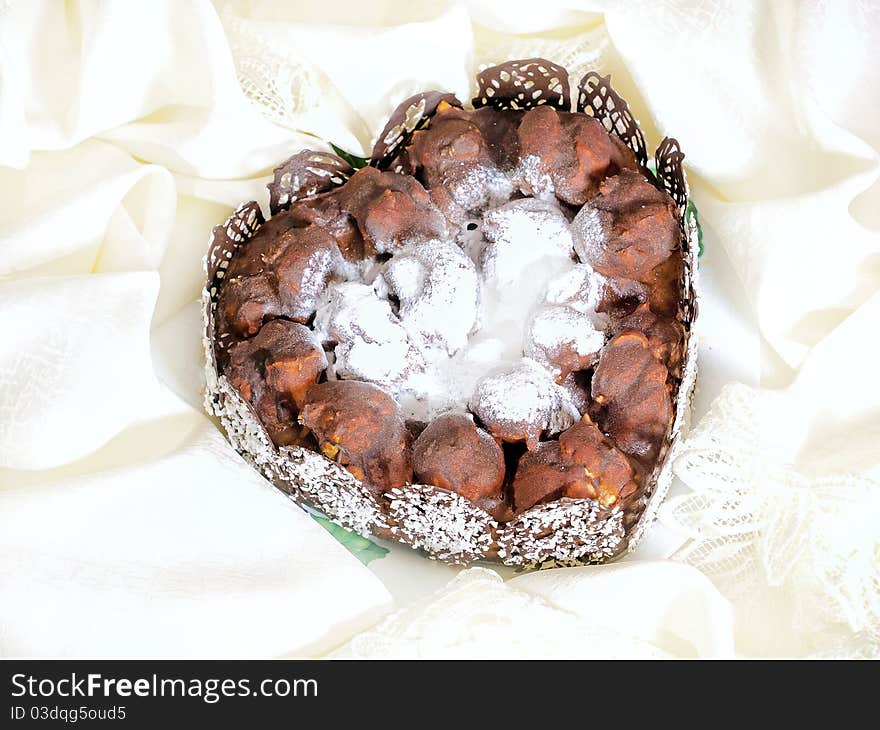 Beautiful heart shaped cake made from profiteroles decorated with chocolate and coconut chips