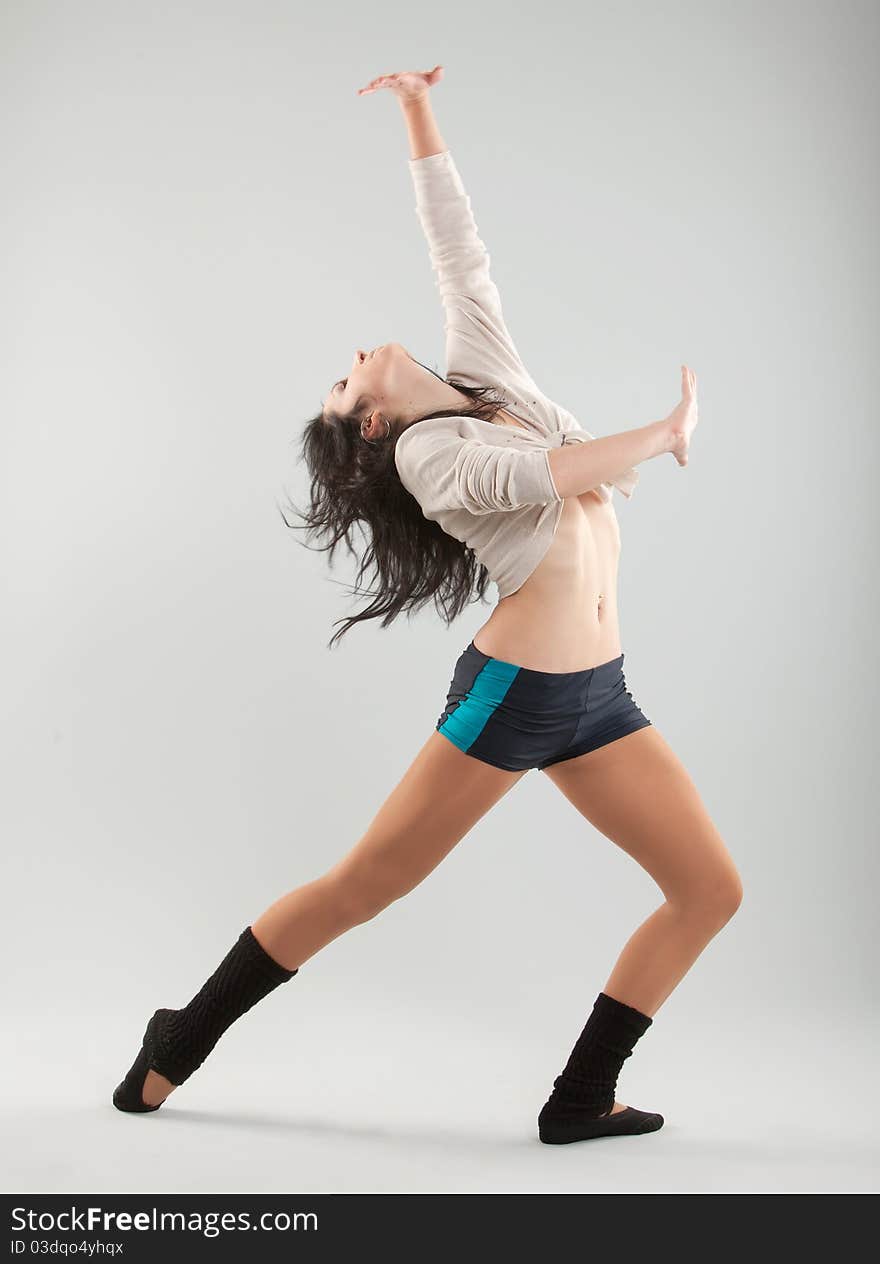 The beautiful girl dances on grey background. The beautiful girl dances on grey background