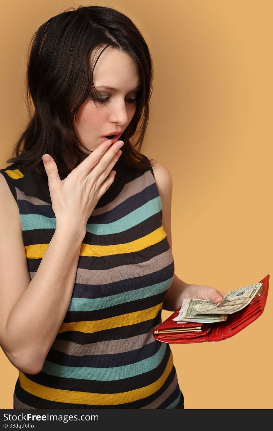 The girl holds a purse with money and surprised. The girl holds a purse with money and surprised