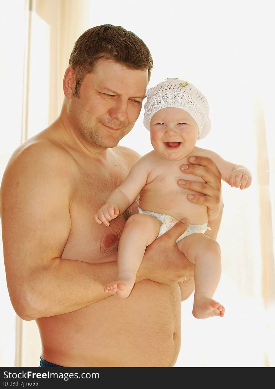 The young man holds a small daughter on a shoulder. The young man holds a small daughter on a shoulder