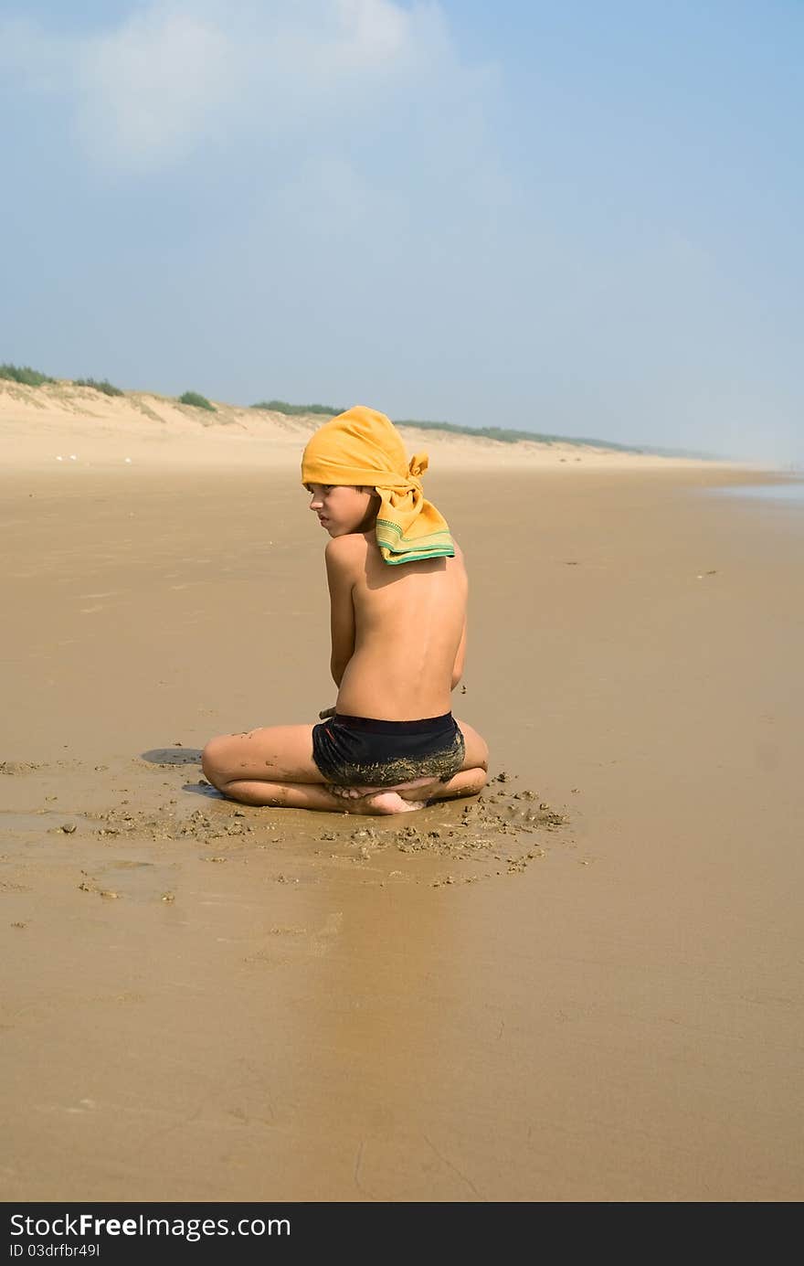 A Boy Sitting On The Sand