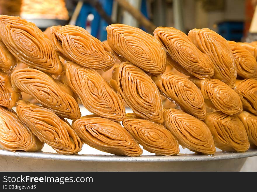 Photo of sweet Indian baklava neatly laid out on thethe edge of of the pelvis. Photo of sweet Indian baklava neatly laid out on thethe edge of of the pelvis