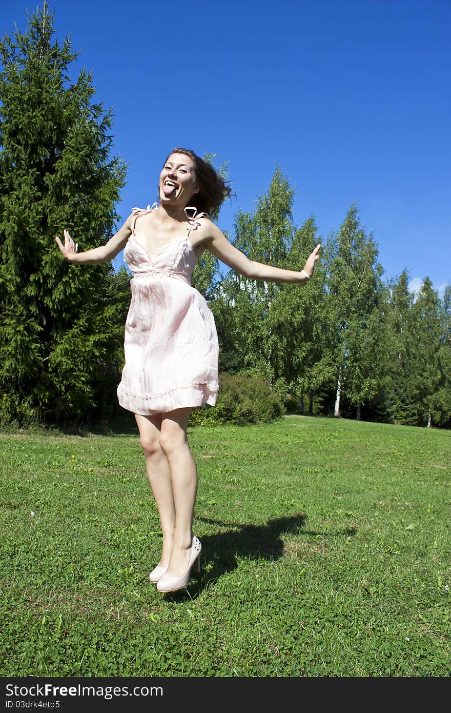 Beautiful young happy woman under blue sky.