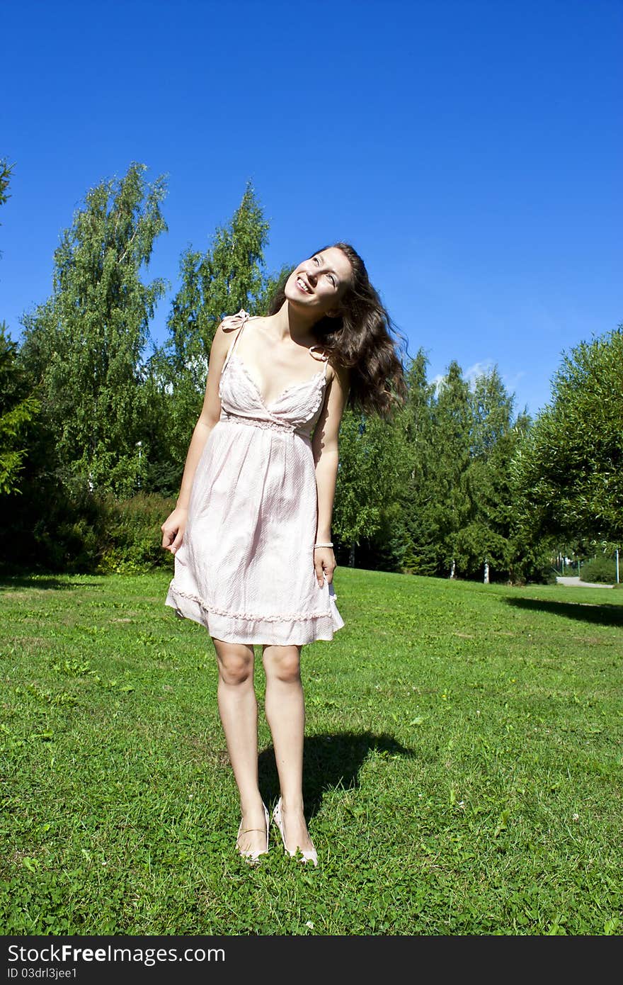 Young happy beautiful girl on the street in the summer. Looking up. Young happy beautiful girl on the street in the summer. Looking up