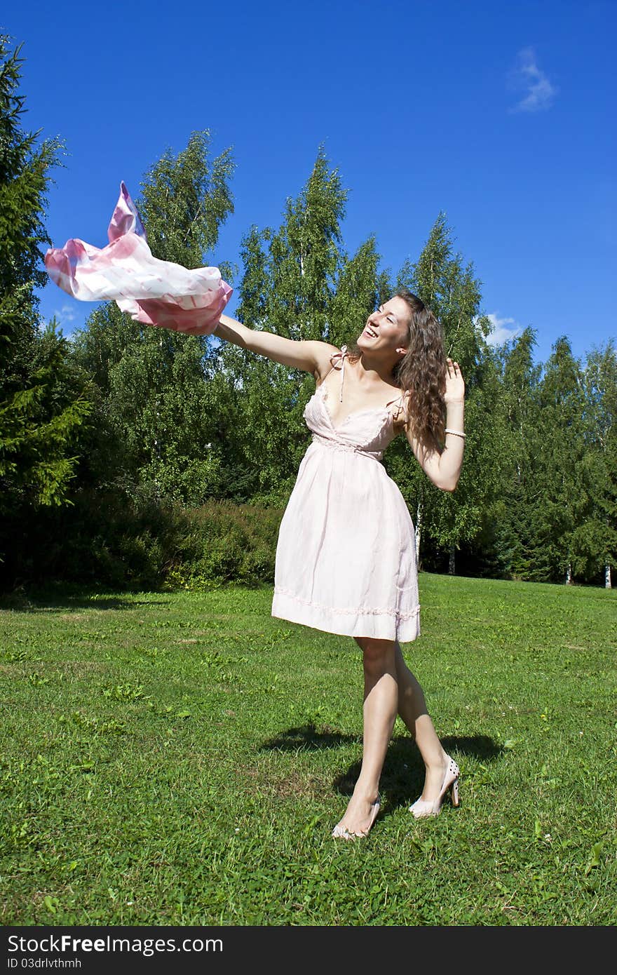 Beautiful young woman dancing with kerchief against the blue sky. Beautiful young woman dancing with kerchief against the blue sky