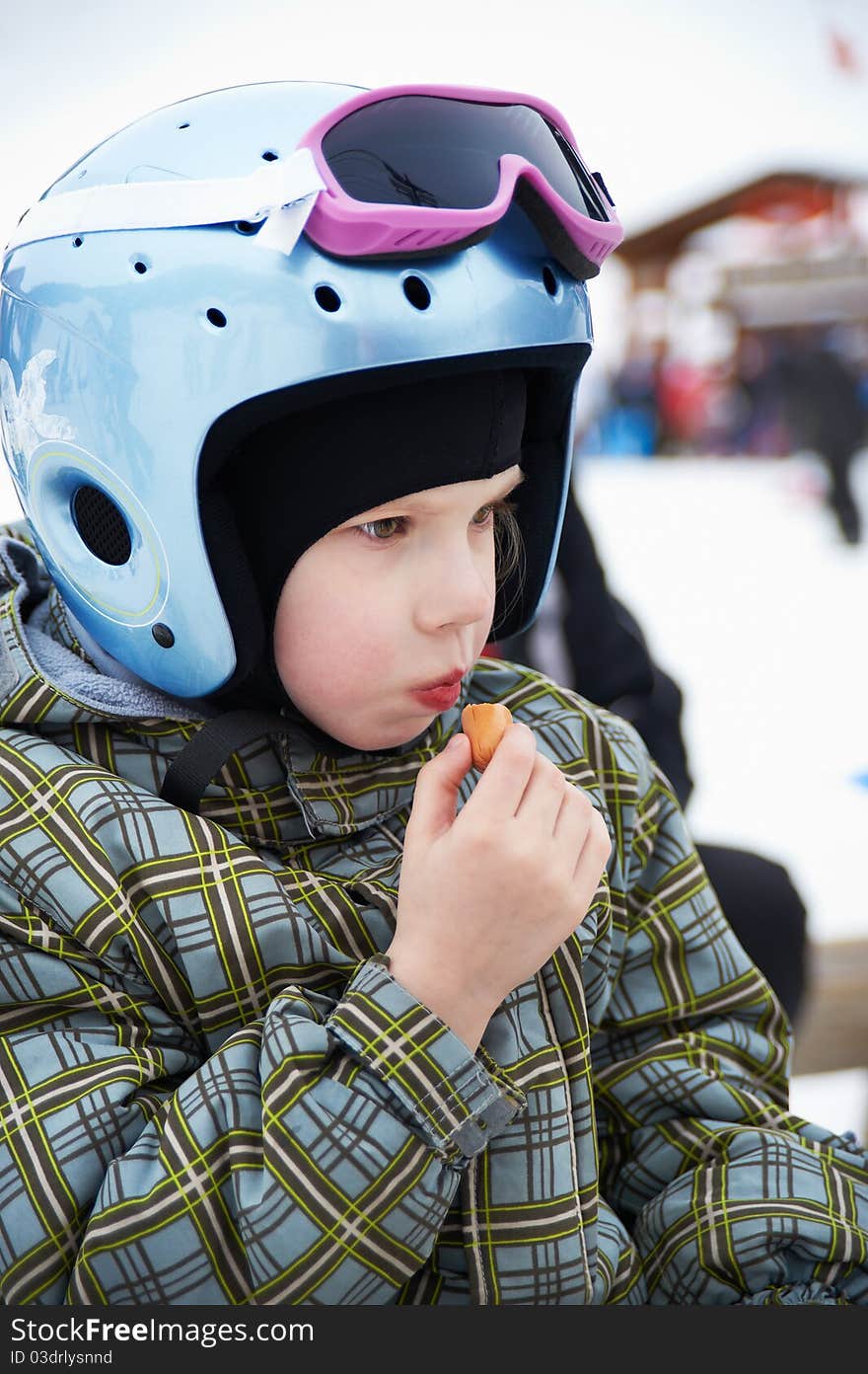 Little Girl In Ski Helmet Eats Sausage