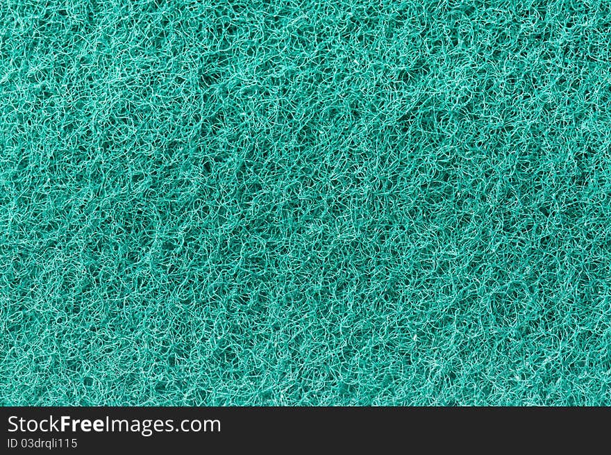 Close-up of a green cleaning sponge surface as a backdrop