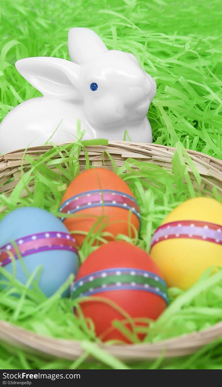 Four easter eggs on a basket and a white rabbit. Four easter eggs on a basket and a white rabbit