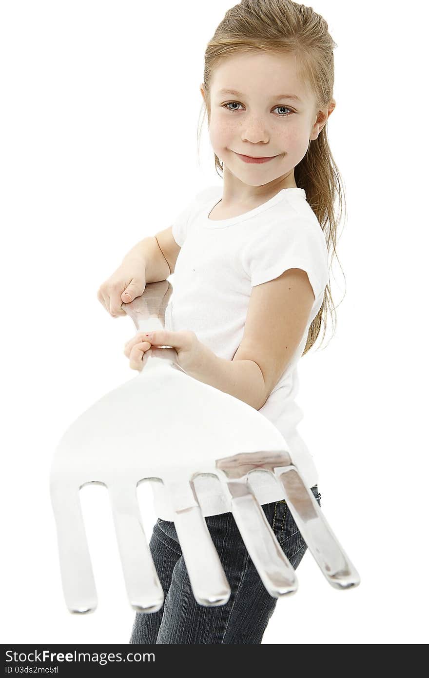 Adorable six year old caucasian girl holding giant fork over white with clipping path. Adorable six year old caucasian girl holding giant fork over white with clipping path.