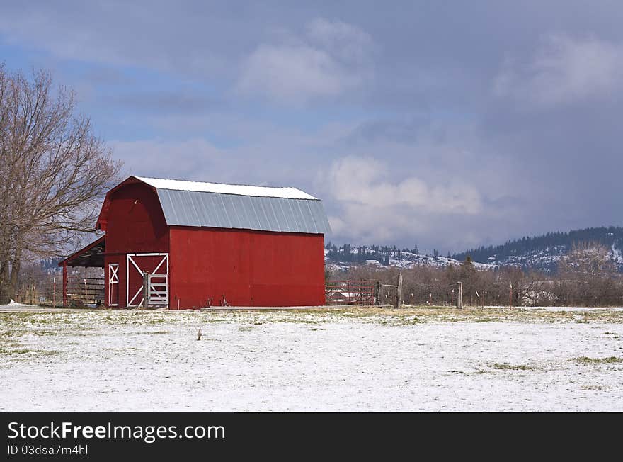 Red barn, blue sky, white snow.