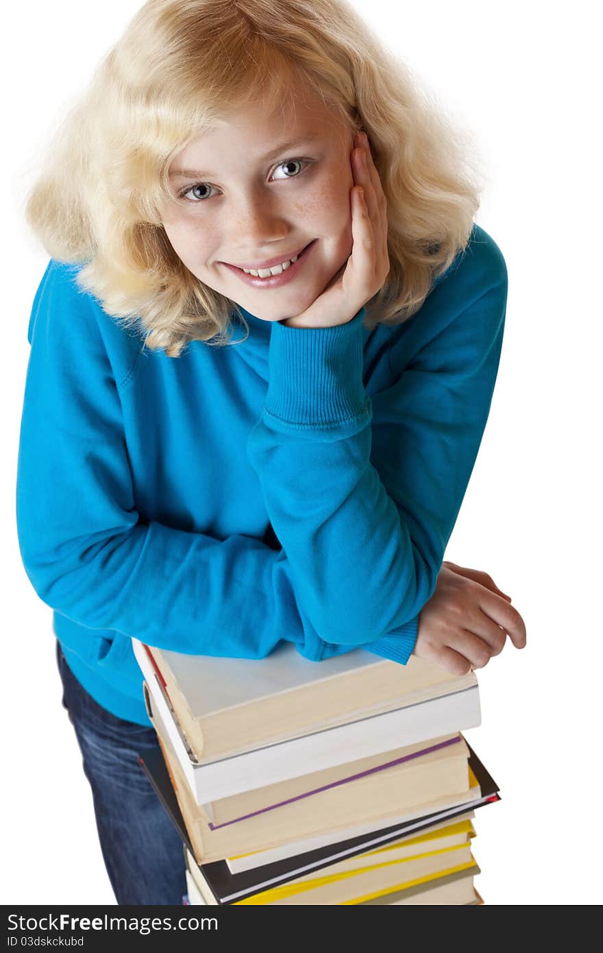 Young pretty schoolgirl leans on study books stack