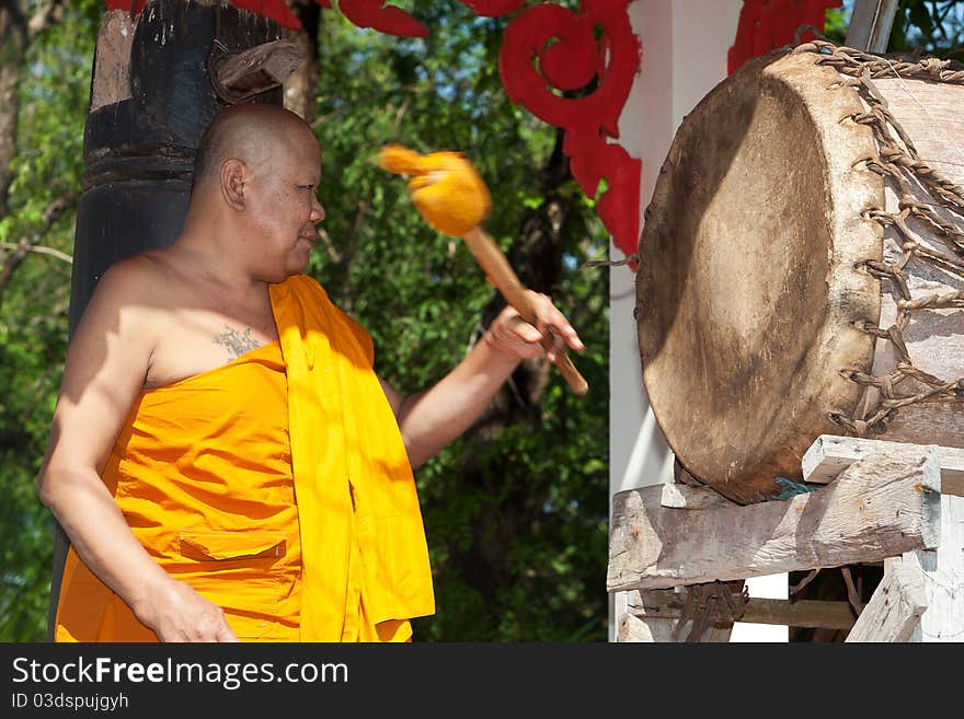 Buddhist monk, hitting the drum in the temple