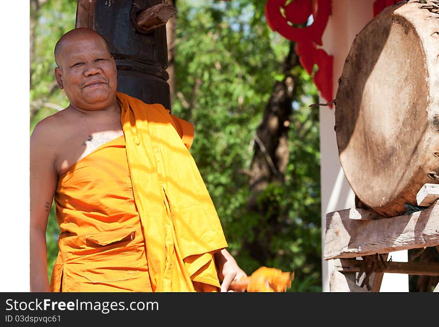 Buddhist monk, hitting the drum in the temple