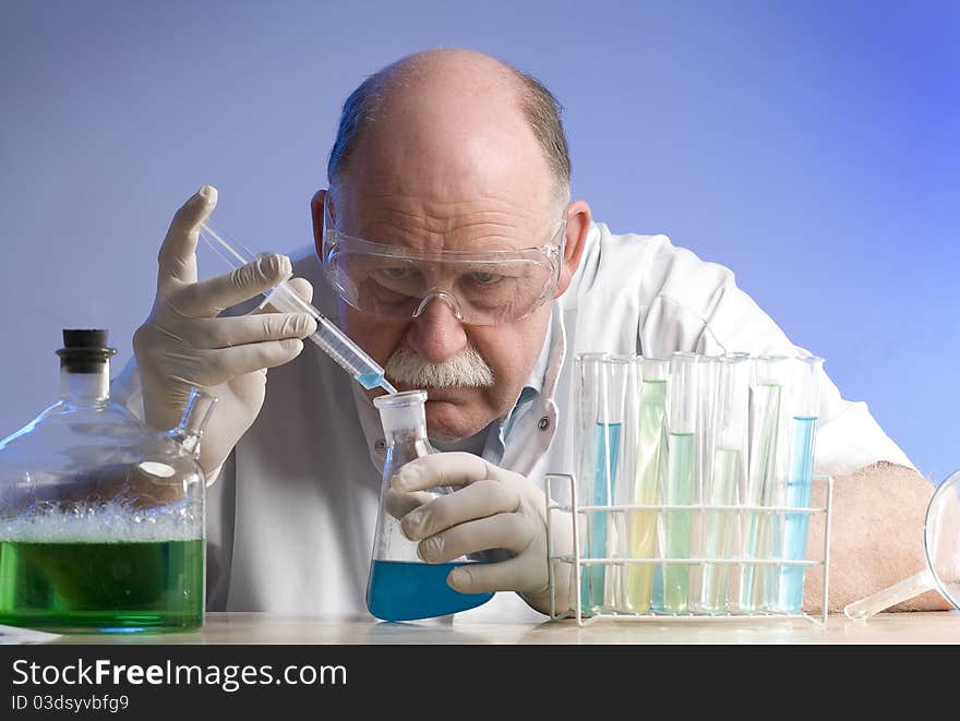 Scientist working with chemicals on blue background