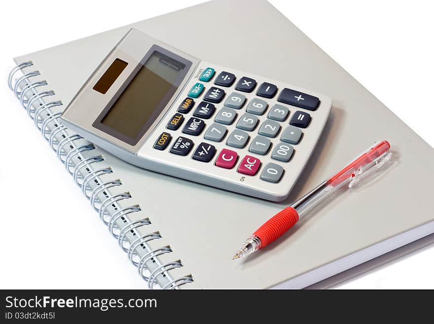 Calculator with book and pen on white background