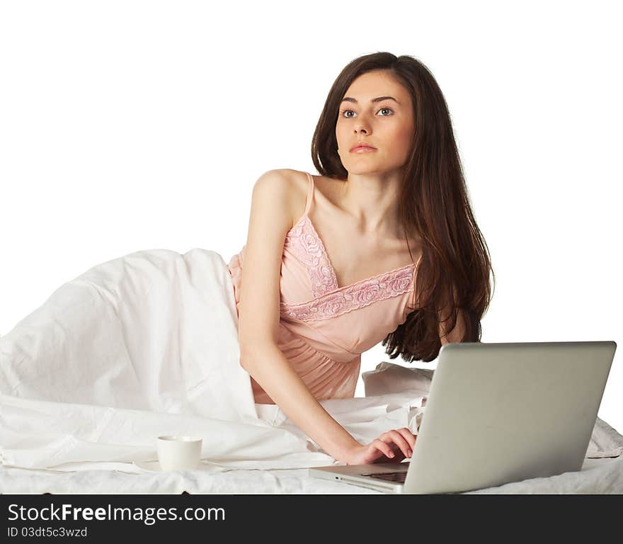 Girl looking up in the bed with laptop on a white background