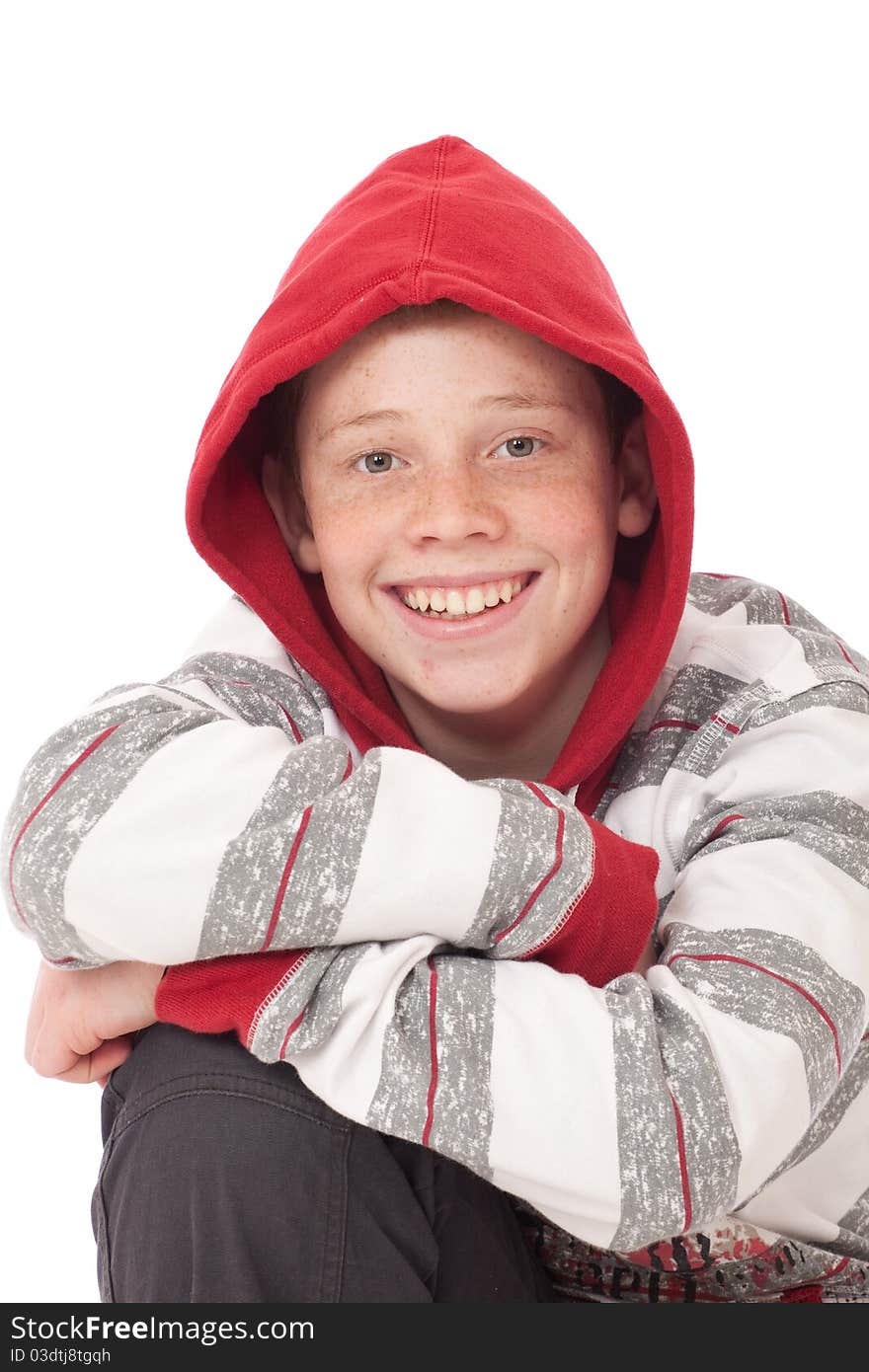 Young teenage boy kneeling with crossed arms and red hood. Young teenage boy kneeling with crossed arms and red hood