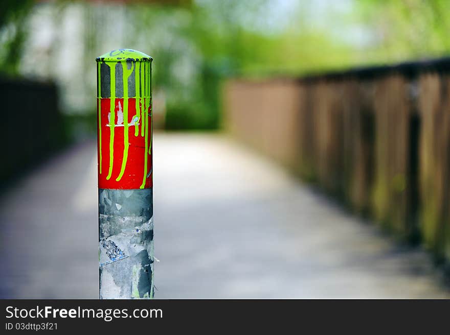 Colorful metal posts in front of a pedestrian bridge