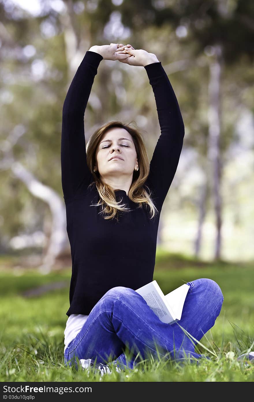 Young woman stretching on the grass