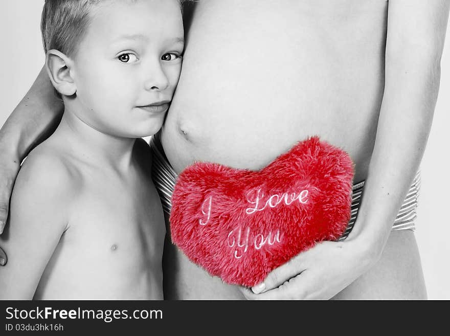 Pregnant mum with her son and toy heart. Pregnant mum with her son and toy heart