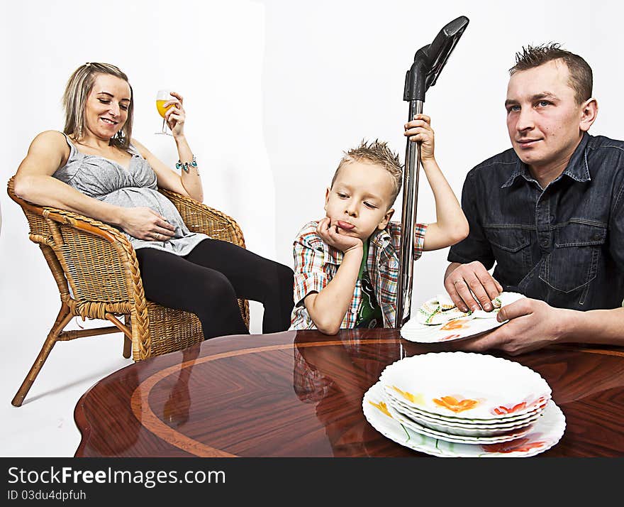 Pregnant mum resting while dad and son do the housework. Pregnant mum resting while dad and son do the housework