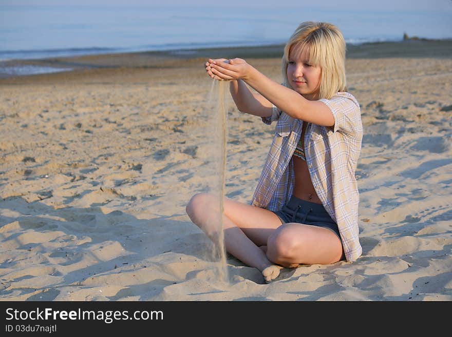 Girl plays sand on beach. Girl plays sand on beach.