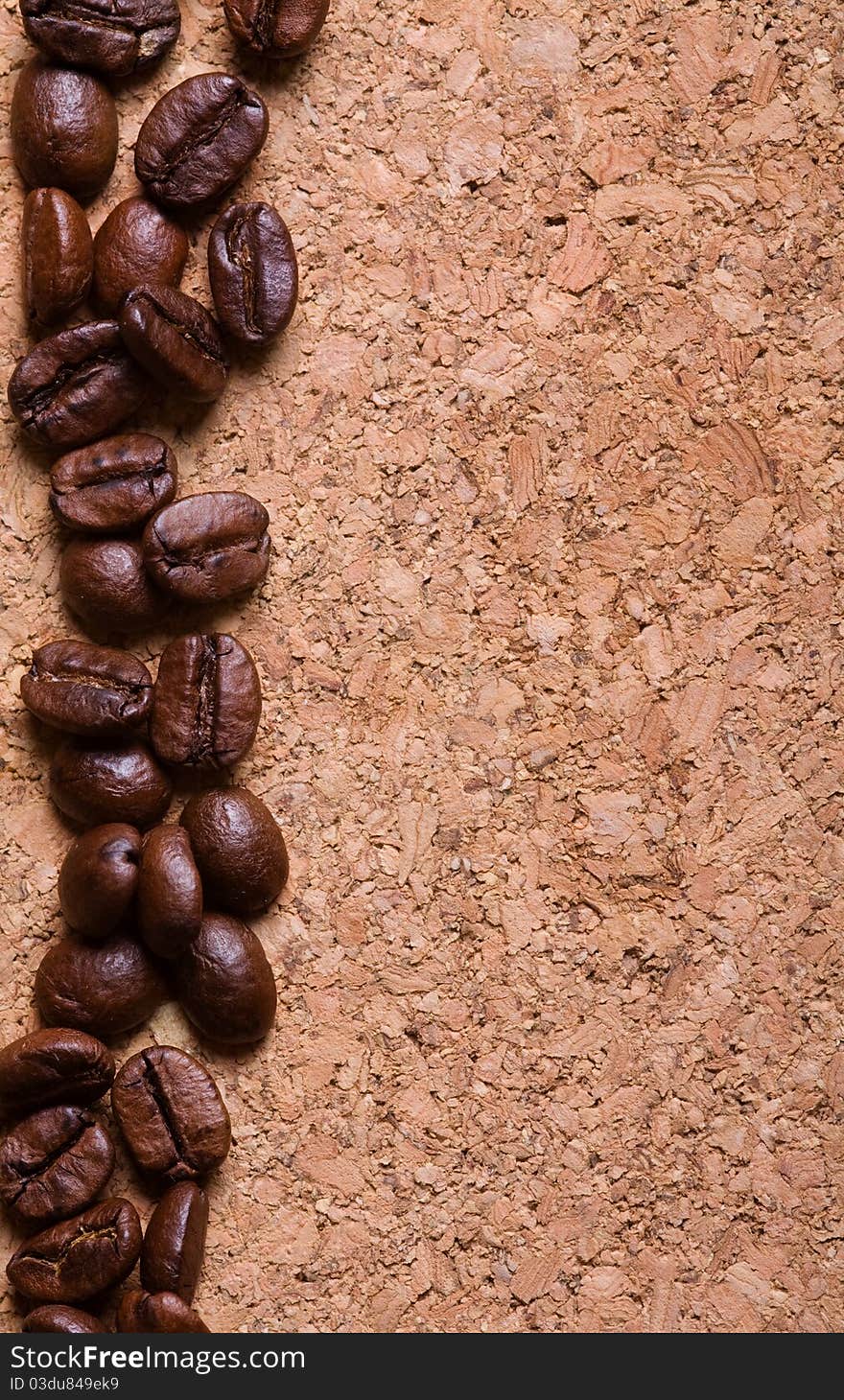 A pile of coffee beans forming a simple stripe frame on a natural corkwood background. A pile of coffee beans forming a simple stripe frame on a natural corkwood background