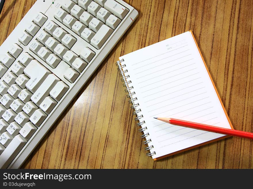 Paper note and keyboard on wood table