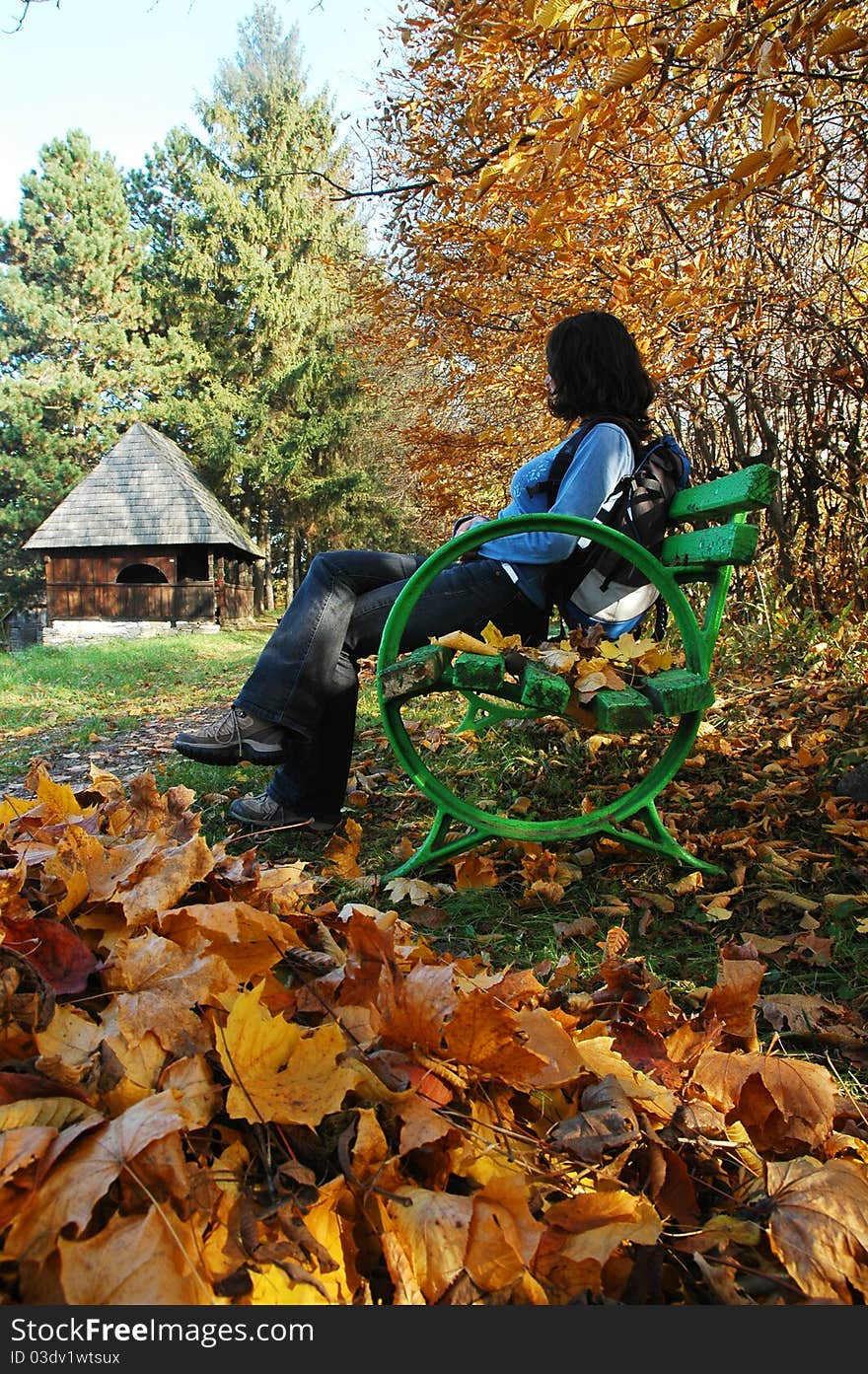 Woman on bench in park at Autumn