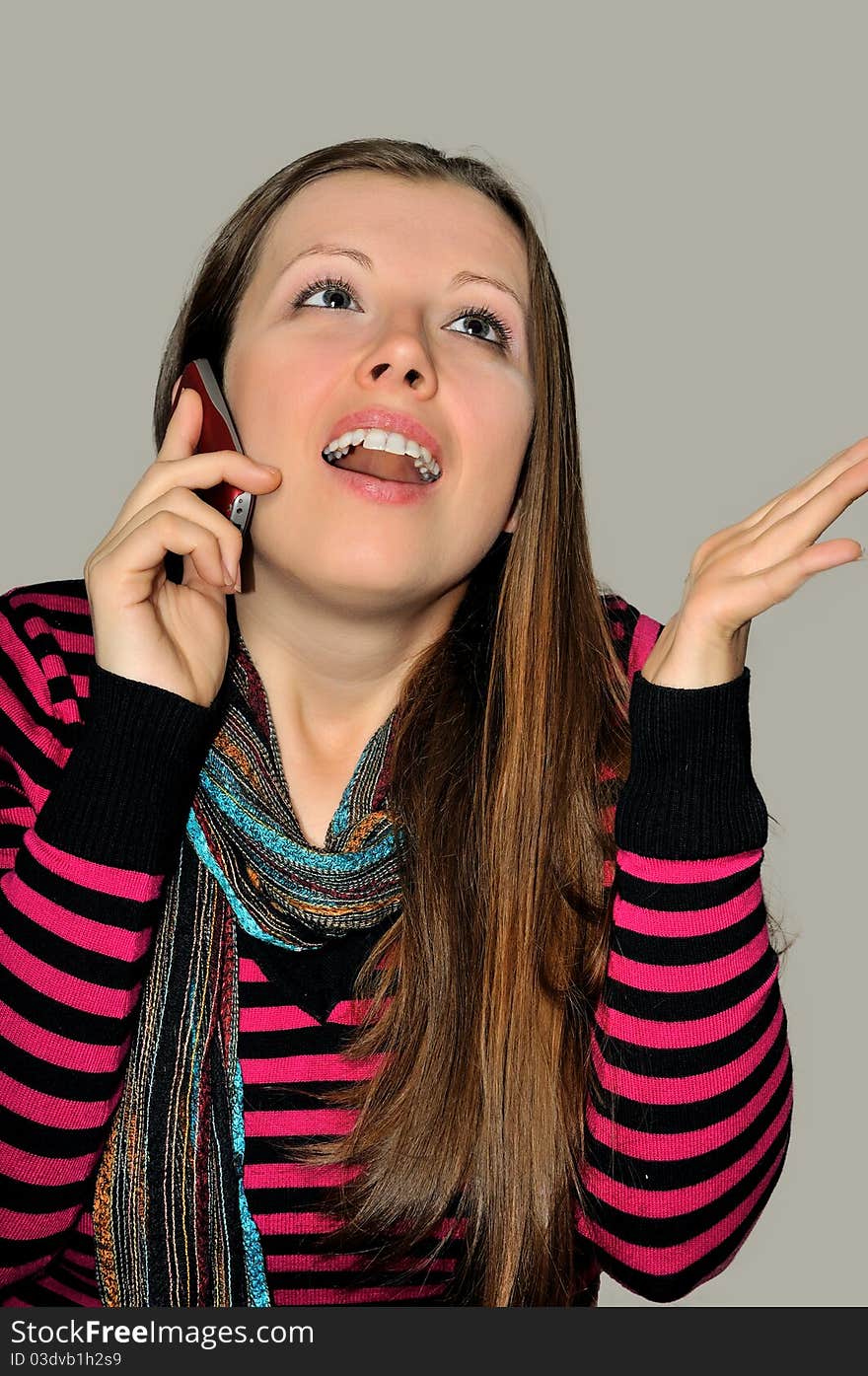 A young girl emotionally expressive talking on a mobile phone. A young girl emotionally expressive talking on a mobile phone